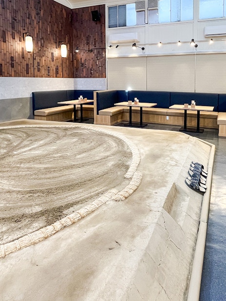 Sumo wrestling arena with seating area in a modern venue.