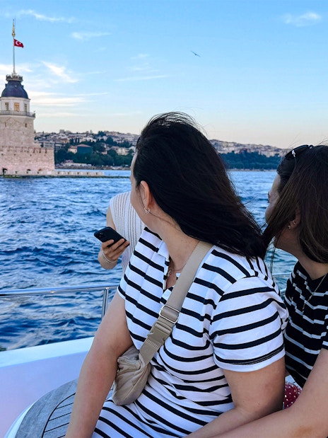 Visitors on a private luxury yacht viewing Maiden's Tower at sunset in Istanbul.