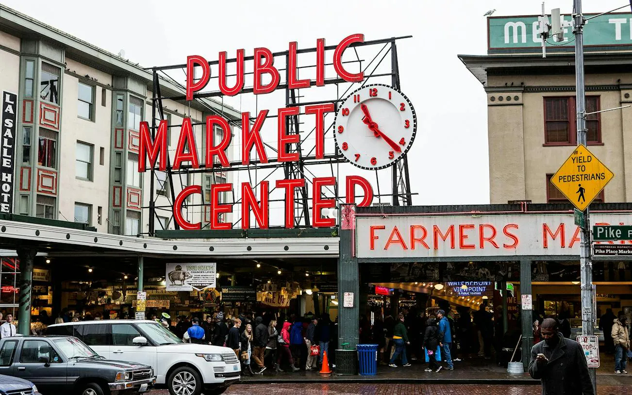 Pike Place Market entrance with clock and crowd, Seattle Harbor of Secrets game location.