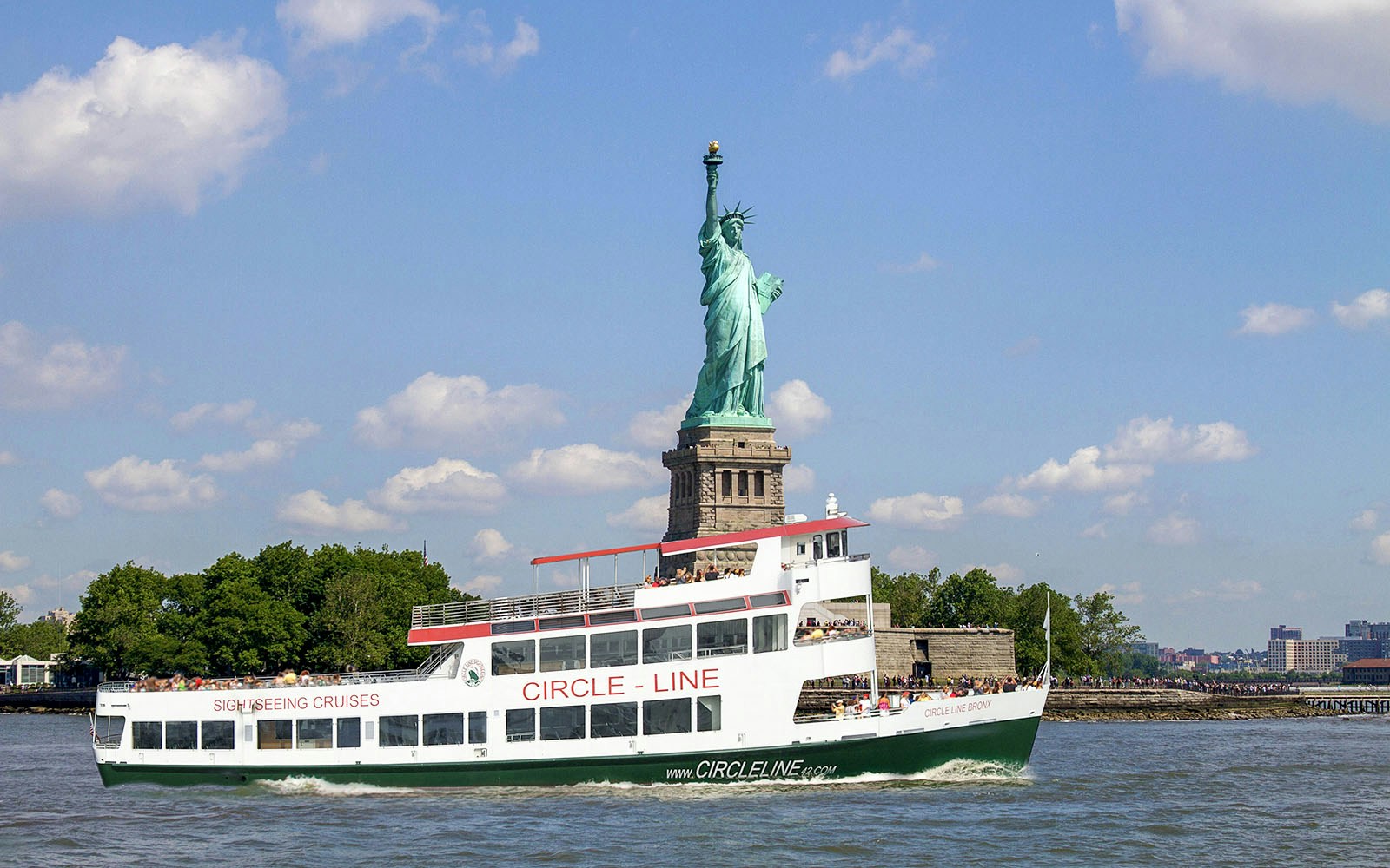 Passengers enjoying the view of Statue of Liberty from the deck of Circle Line: Liberty Midtown Cruise in New York