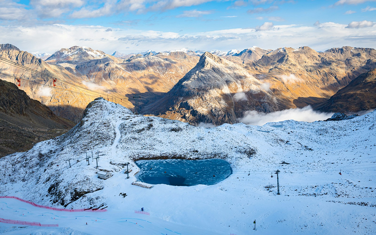 Small turquoise colored lake surrounded by fresh snow near Refuge Diavolezza in the Bernina mountain range, Switzerland.