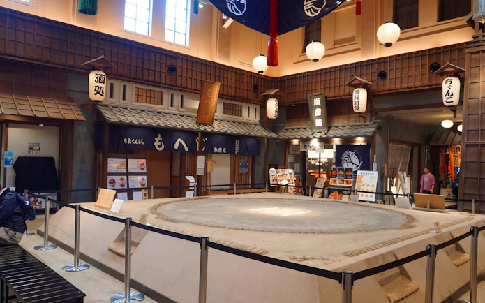 Sumo wrestling ring in Ryogoku, Tokyo, surrounded by traditional Japanese decor and eateries.