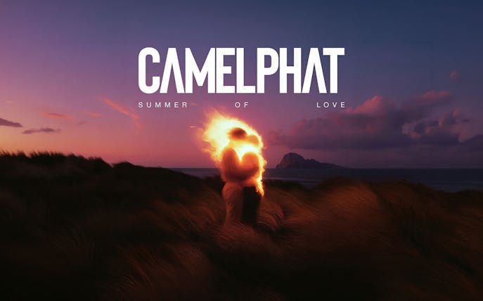Couple embracing with fiery glow at sunset, Ibiza coastline in background, Camelphat event.