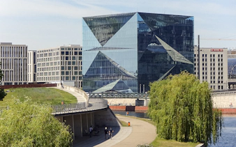 Modern glass building along the Spree River in Berlin during sightseeing cruise.