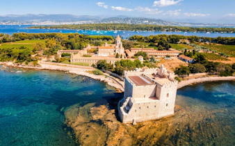 Lérins Island with historic abbey and fort, viewed from catamaran on Marina Bay of Angels cruise.