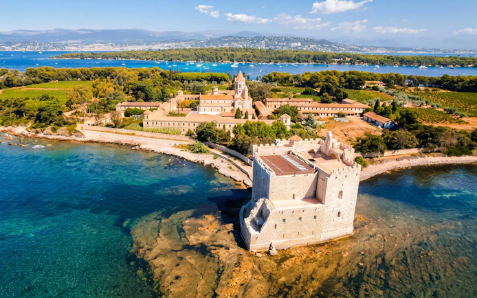 Lérins Island with historic abbey and fort, viewed from catamaran on Marina Bay of Angels cruise.
