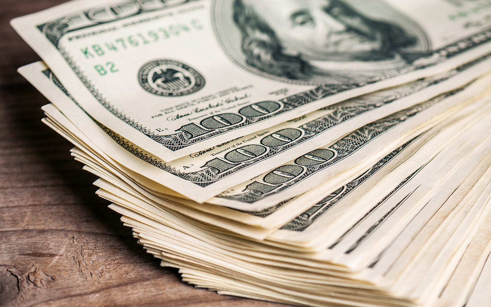 Pila de billetes de dólar estadounidense que representan ahorros.