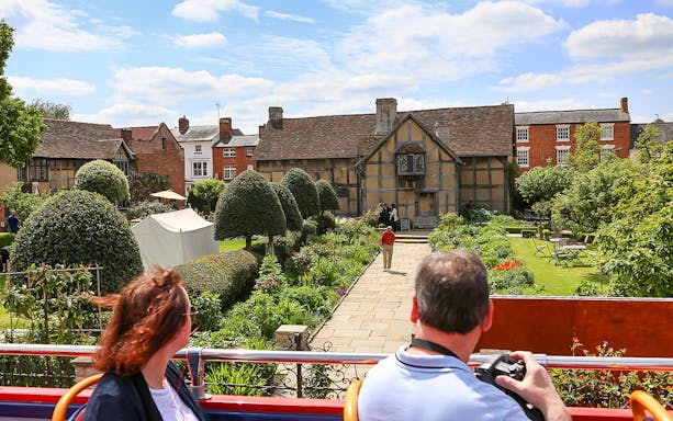 Visitors on a HOHO bus view Shakespeare's Birthplace in Stratford-upon-Avon.