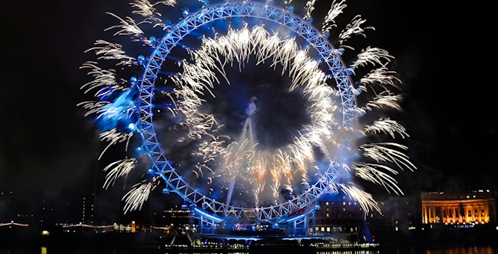 Fireworks illuminate the London Eye on New Year's Eve over the River Thames.