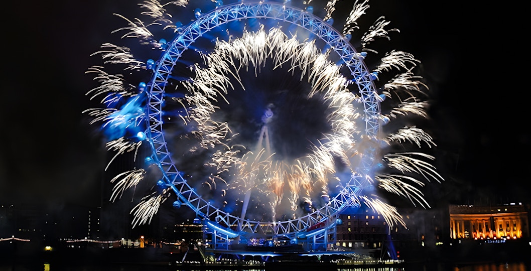 Fireworks illuminate the London Eye on New Year's Eve over the River Thames.