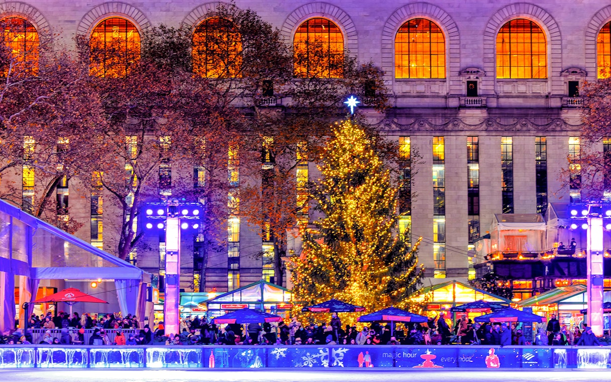 Holiday lights and decorated tree at a festive ice rink in New York City.