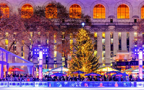 Holiday lights and decorated tree at a festive ice rink in New York City.