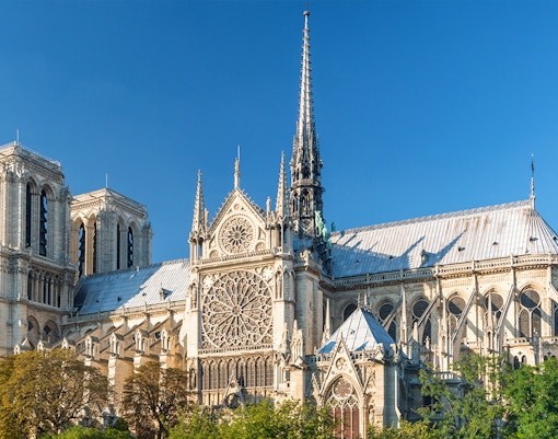 Notre Dame Cathedral facade in Paris with tourists exploring the historic site.