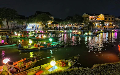 Boat ride with colorful lanterns on a canal at night, Dubai, offering a free herbal drink.