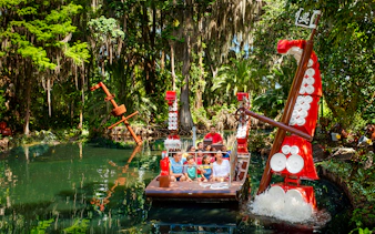 Visitors on a boat ride through a lush, pirate-themed river at Legoland Florida.