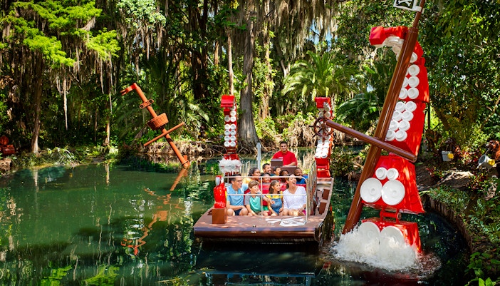 Visitors on a boat ride through a lush, pirate-themed river at Legoland Florida.