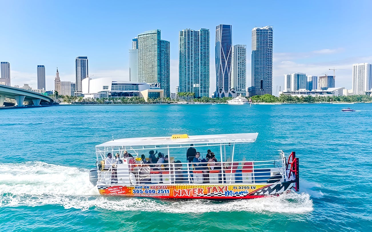 Water taxi cruising with Miami skyline in the background.