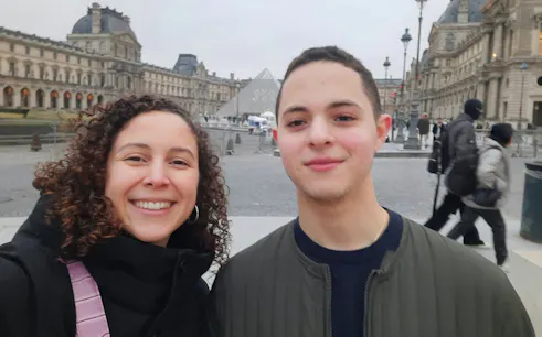 Visitors in front of the Louvre Pyramid, Paris, during a self-guided city exploration game.