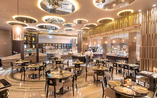 Buffet dining area at Mundo Jumeirah Emirates Towers with tables and food stations.