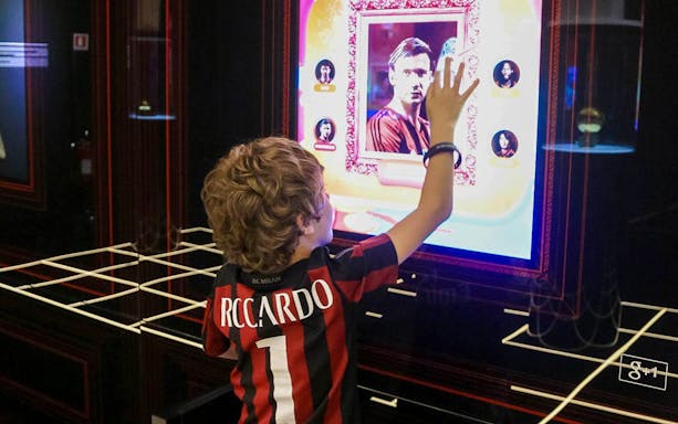 Child interacting with digital display at Casa Milan museum.