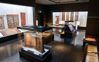 Rug exhibit at Kyushu National Museum showcasing intricate patterns and designs.