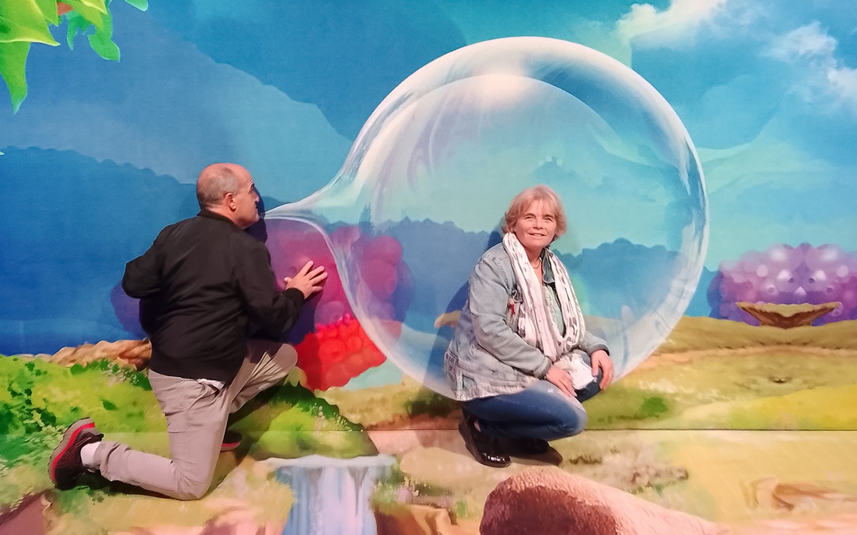 Guests interacting with a large bubble display inside Bubble Planet Berlin.