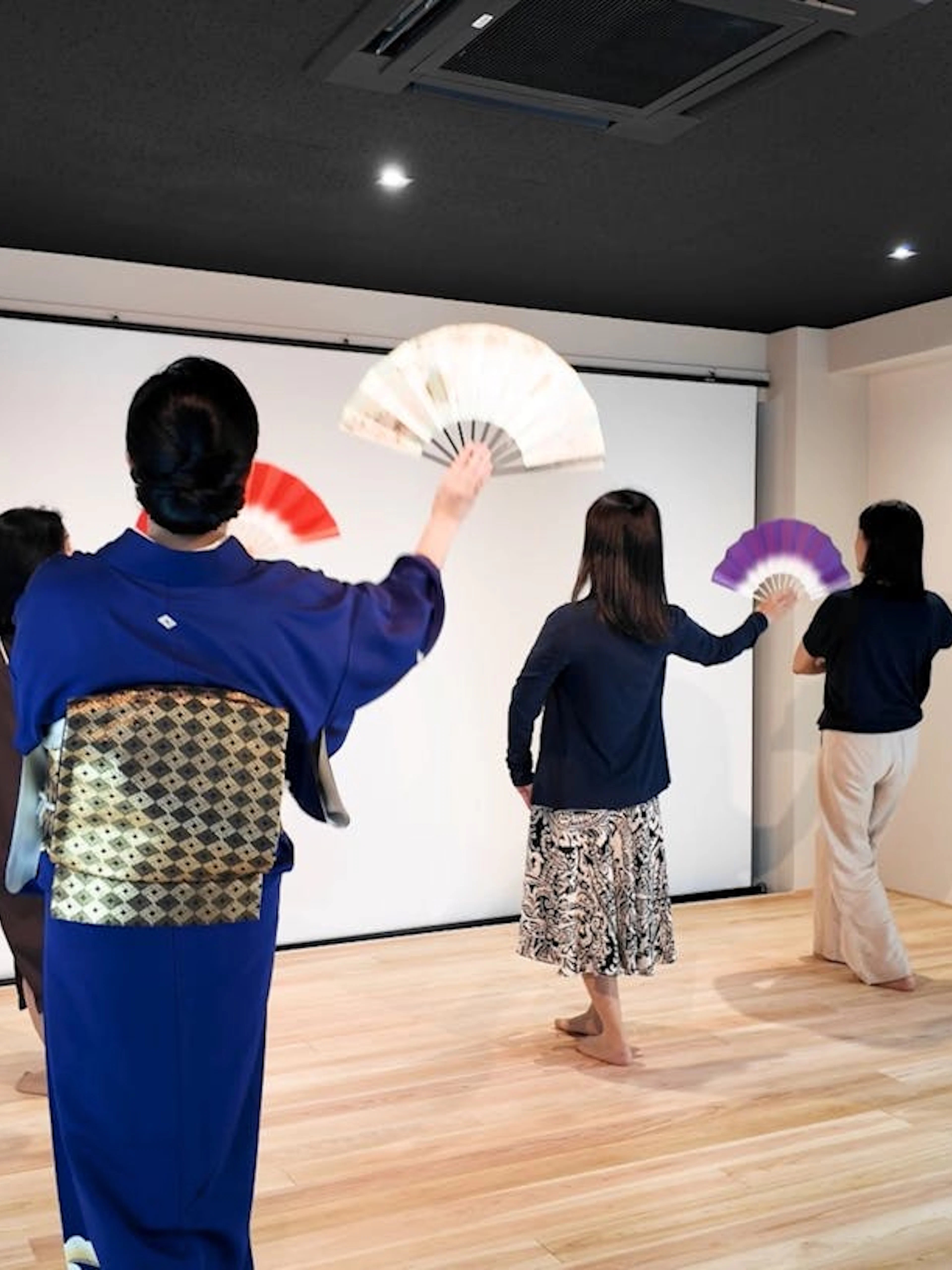 Participants learning traditional Japanese dance with fans in Kyoto workshop.