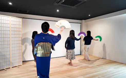 Participants learning traditional Japanese dance with fans in Kyoto workshop.