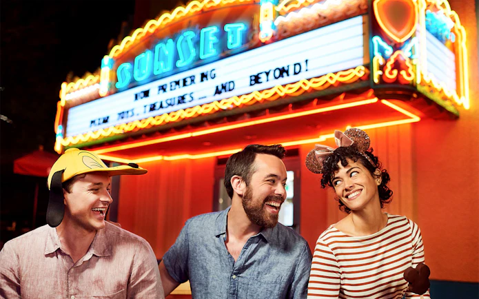 Friends laughing outside a movie theatre at Disney's Hollywood Studios, Orlando.