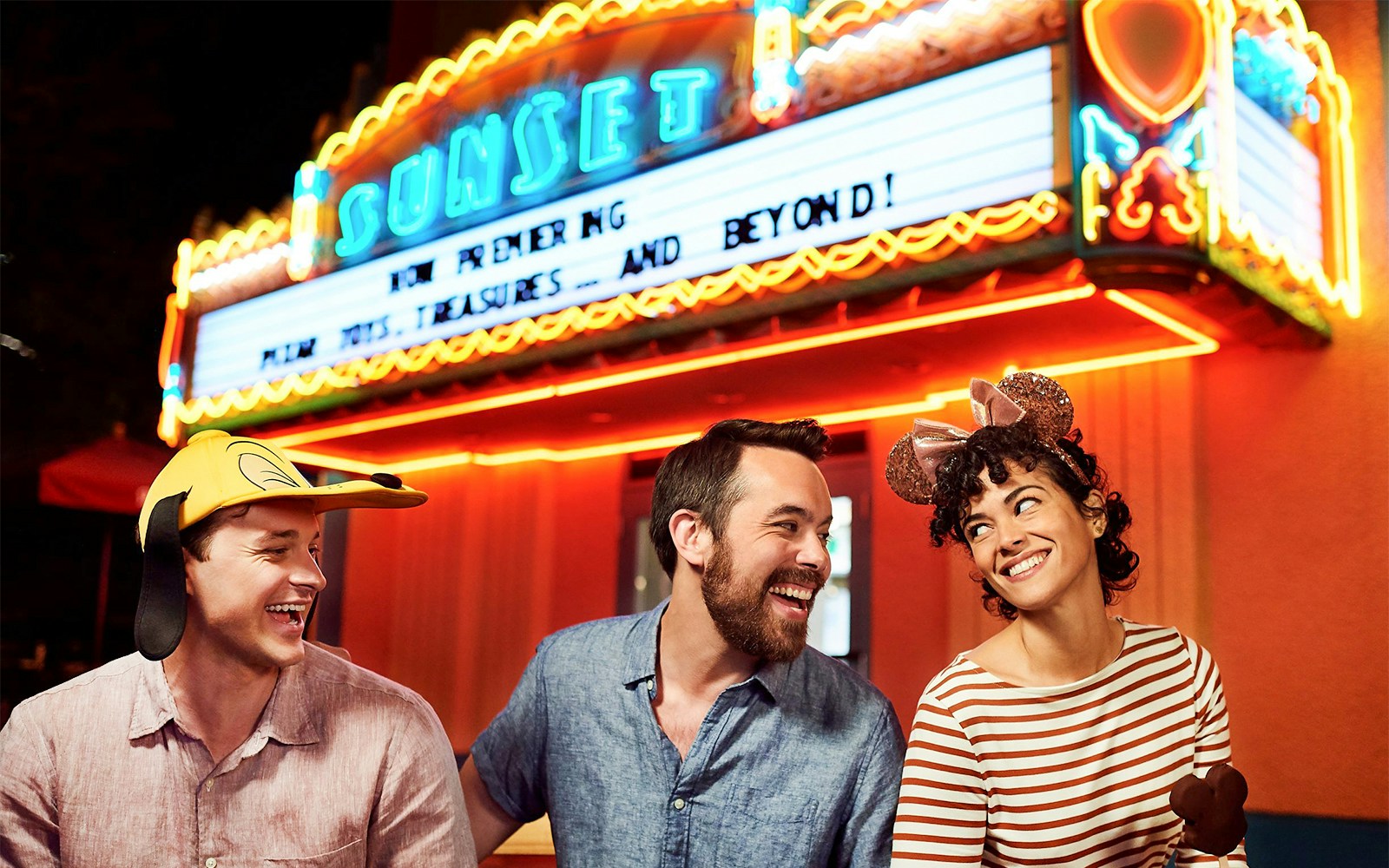Friends laughing outside a movie theatre at Disney's Hollywood Studios, Orlando.