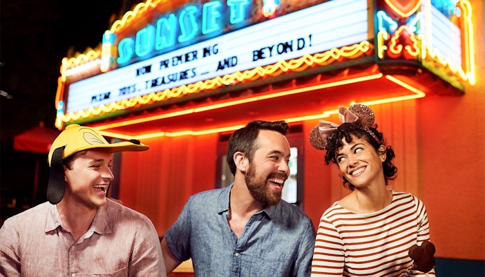 Friends laughing outside a movie theatre at Disney's Hollywood Studios, Orlando.