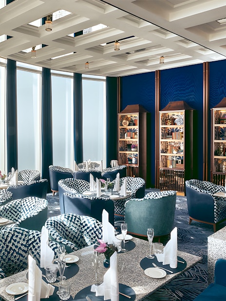 Dining area at At.mosphere Burj Khalifa with elegant seating and panoramic city views.