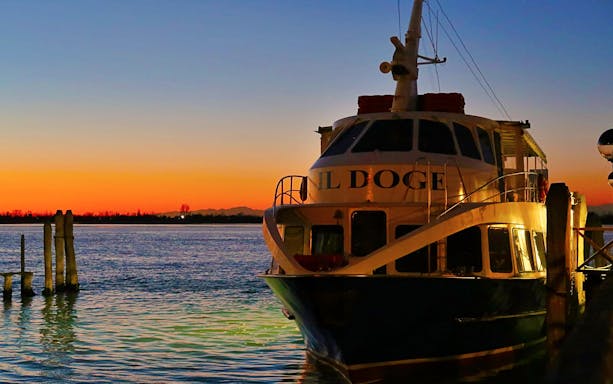 Boat docked at Punta Sabbioni during sunset, starting Venice night tour.