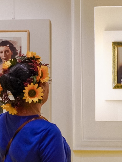 Visitors viewing a portrait of Frida Kahlo at the Frida Kahlo Museum.