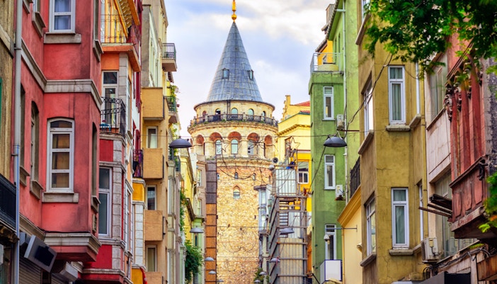 Galata Tower overlooking Bosphorus with cruise ships in Istanbul, Turkey.