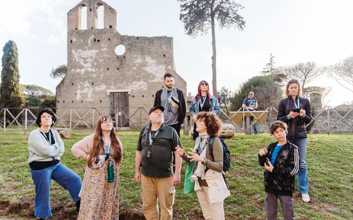 Tour group exploring ancient ruins on the Appian Way during the Underground Rome Catacombs Tour.