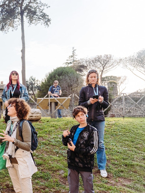 Tour group exploring ancient ruins on the Appian Way during the Underground Rome Catacombs Tour.