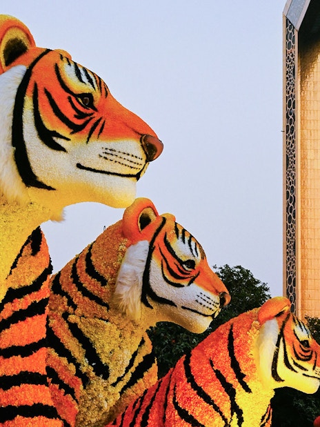 Floral tiger sculptures at Dubai Garden Glow with Dubai Frame in the background.