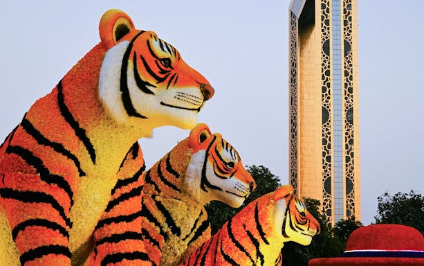 Floral tiger sculptures at Dubai Garden Glow with Dubai Frame in the background.