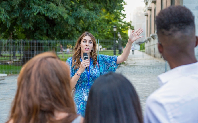 Tour guide speaking to a group at Windsor Castle on a sunny day.
