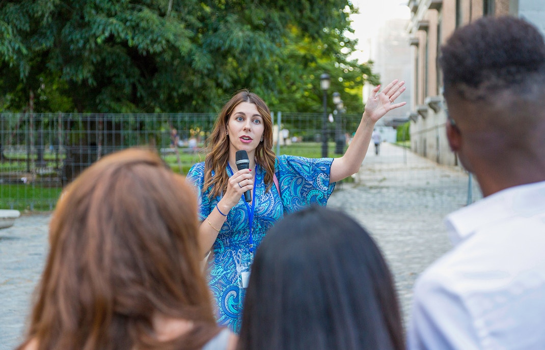 Tour guide speaking to a group at Windsor Castle on a sunny day.