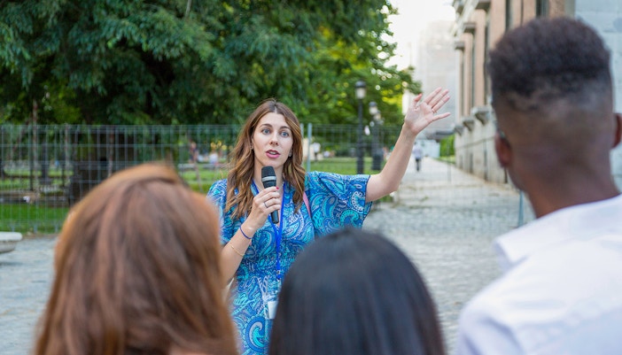 Tour guide speaking to a group at Windsor Castle on a sunny day.