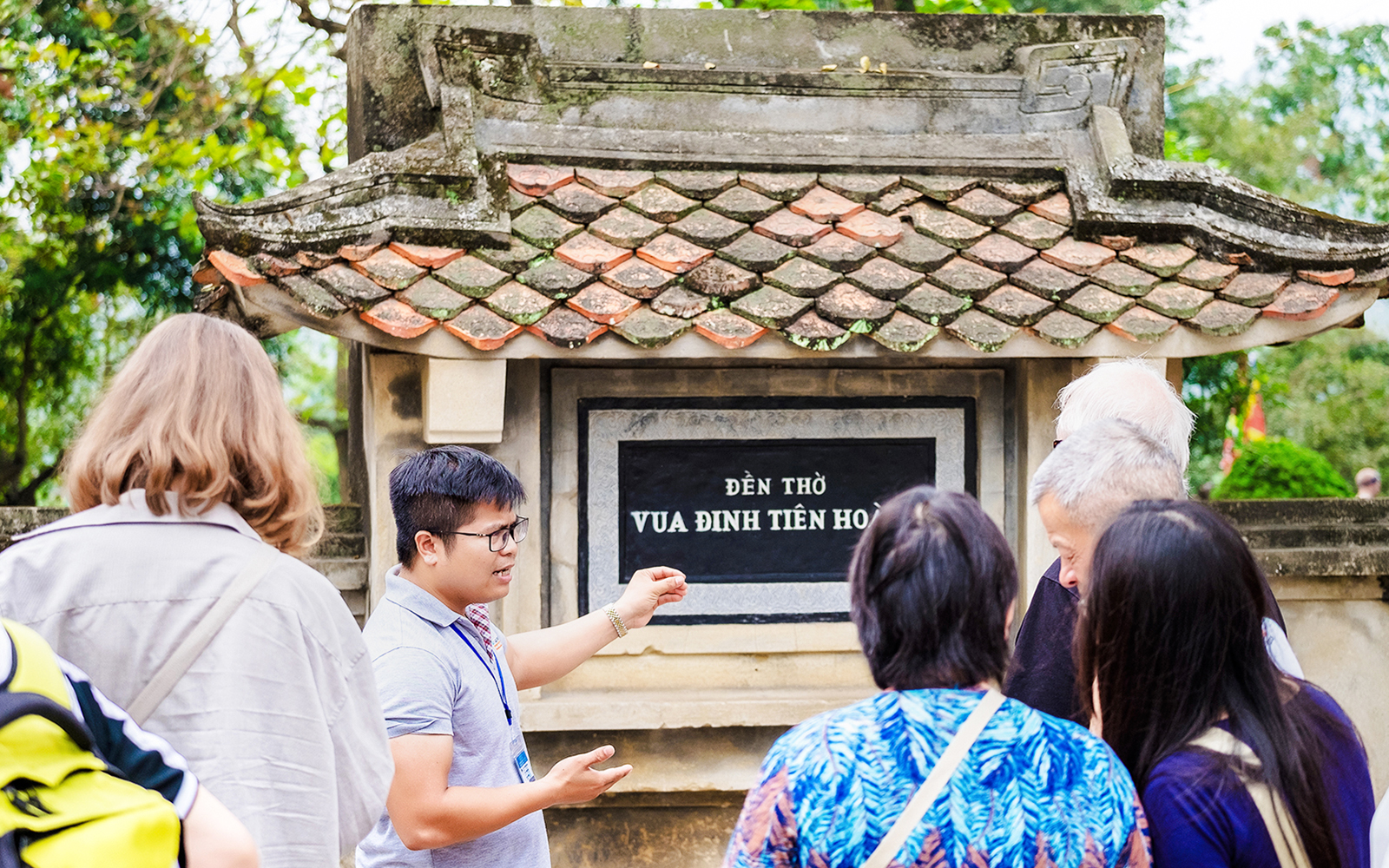 Tour guide explaining Đinh Tiên Hoàng Temple to visitors at Hoa Lư Ancient Capital, Ninh Bình, Vietnam.