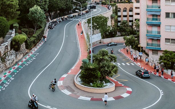 Monaco Grand Prix circuit with cars and pedestrians on a winding street.