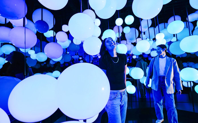 Visitors enjoying illuminated spheres at Edge NYC Observation Deck.