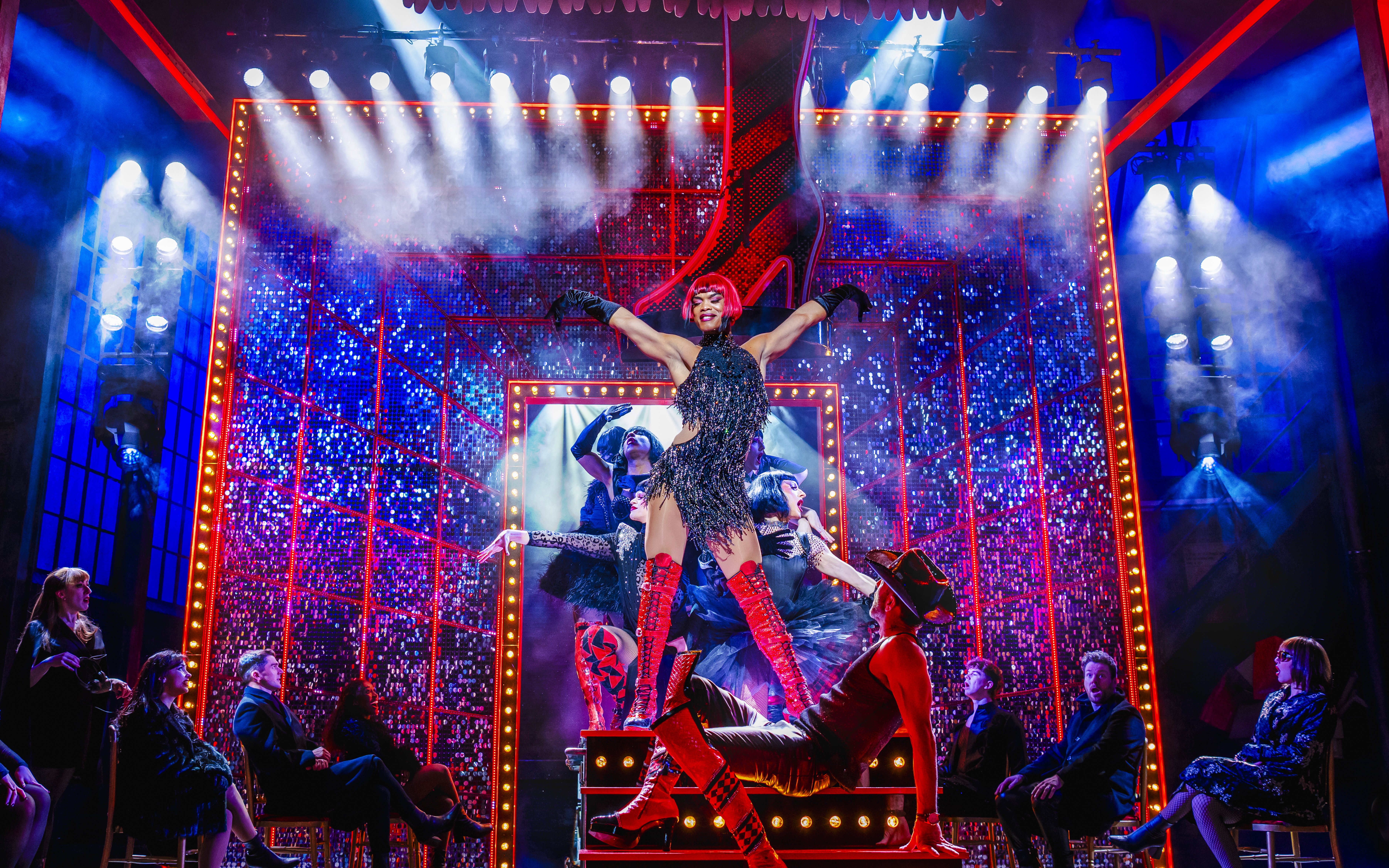 Performer in red boots on stage during Kinky Boots musical production.