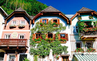 Colorful traditional houses in Hallstatt with flower boxes, part of the Hallstatt Highlights Day Trip from Vienna.