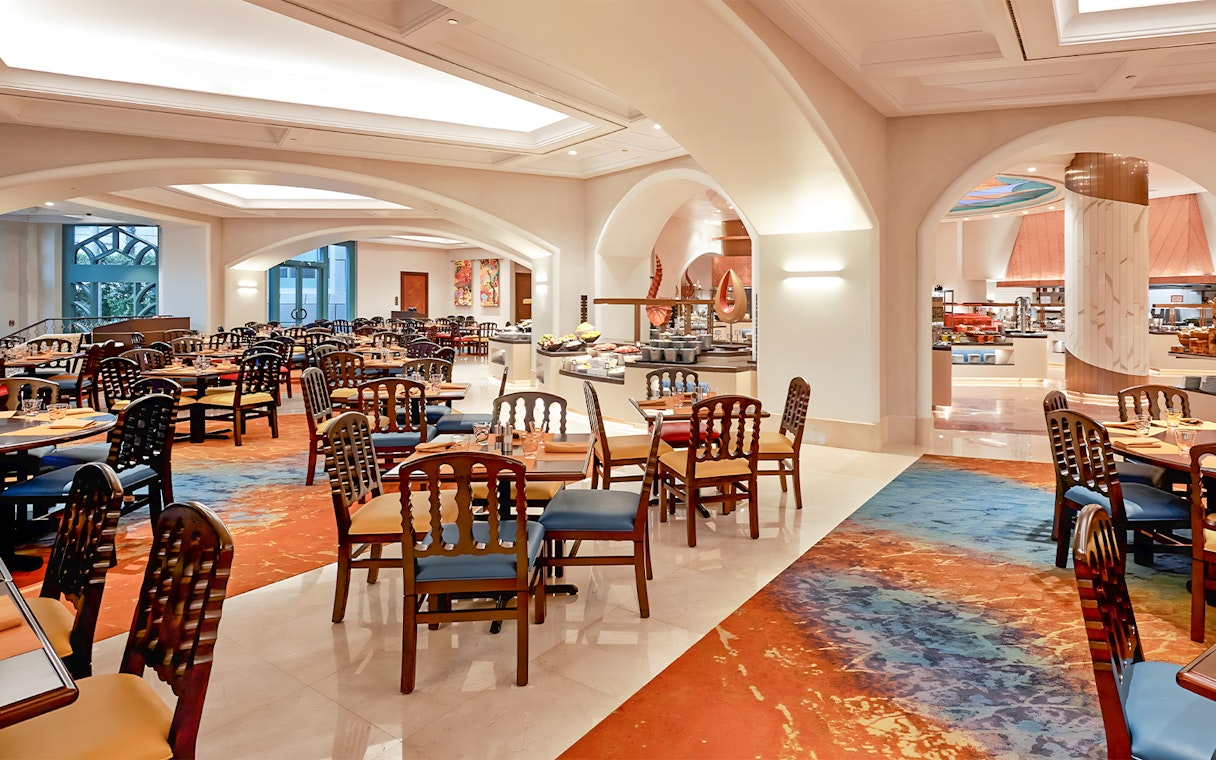 Seating area in Kaleidoscope restaurant, Atlantis Dubai, with colorful decor and dining tables.