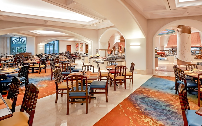 Seating area in Kaleidoscope restaurant, Atlantis Dubai, with colorful decor and dining tables.