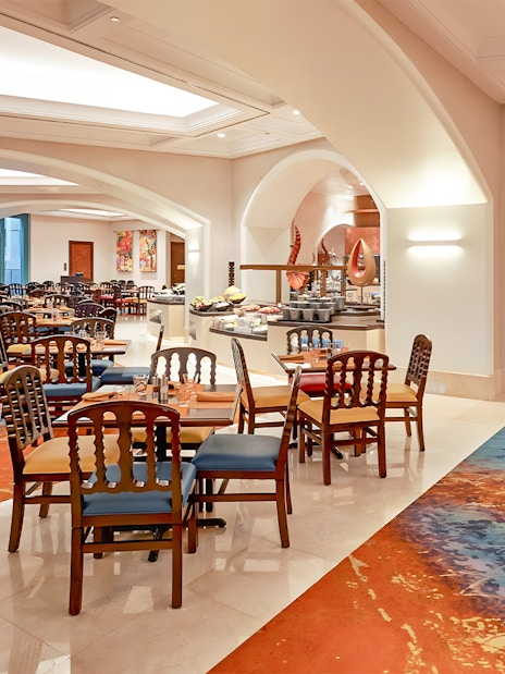 Seating area in Kaleidoscope restaurant, Atlantis Dubai, with colorful decor and dining tables.